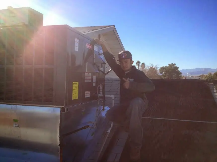 HVAC technician performing AC Tune-Up on a rooftop unit in West Haven-Sylvan